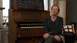 Volker Bertelmann sitzt in seinem Tonstudio in Düsseldorf-Flingern vor seinem Harmonium 
