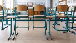 Schulklasse mit aufgestellten Stühlen