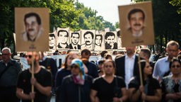 München 2018: Demonstranten halten bei einer Kundgebung Schilder mit Porträt-Abbildungen der NSU-Opfer.