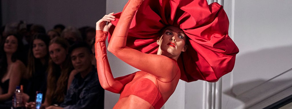Model in einem roten Kostüm auf der New York Fashion Week.
