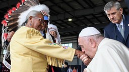 Der Papst küsst einer Indigenin die Hand
