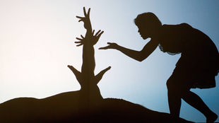 Schattenbild: Silhouette einer Frau, die sich vorsichtig in Richtung des Schattens mehrerer Hände zubewegt (Symbolbild).