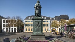 Beethoven-Denkmal auf dem Münsterplatz in Bonn, im Hintergrund das Postamt.