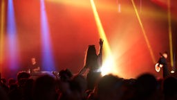 Fans vor einer Konzertbühne im Scheinwerferlicht