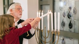 In der jüdischen Gemeinde Herford wird das Lichterfest Chanukka gefeiert. Kantor Jakow Zelewitsch entzündet mit einem Kind die Kerzen an der Menora (Chanukka Leuchter).