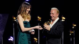 Molly Tuttle (l) überreicht Yannick Nezet-Seguin den Grammy 2024 für die beste Opernaufnahme für "Blanchard: Champion".