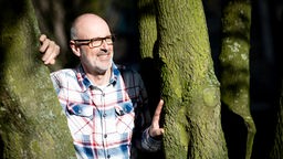 Peter Wohlleben, Förster und Bestseller-Autor, steht nach einem Pressegespräch an einem Baum