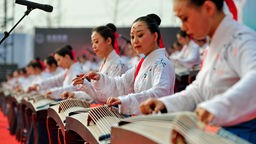 Frauen spielen die chinesische Zither Guzheng im Rahmen der Cangzhou Tourism Industry Development Conference 2020.