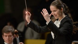 Olha Dondyk dirigiert ein Orchester.
