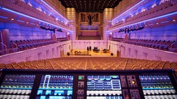 Der Blick in das leere Konzerthaus in Dortmund, im Bildvordergrund steht ein großes Mischpult mit leuchtenden Tasten.