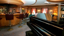 Symbolbild: Ein schwarzes Pianobar steht in einer beahglichen Hotelbar.