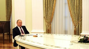 Der russische Präsident sitzt bei dem Treffen mit Olaf Scholz am 15.02.2022 an einem langen ovalen Tisch. Den deutschen Bundeskanzler sieht man auf dem Foto nicht.