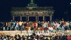 Menschen steigen in Berlin auf die Mauer nach der Öffnung 9. November 1989