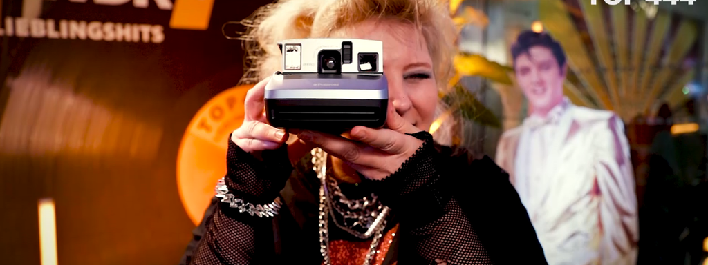 WDR 4-Moderatorin Cathrin Brackmann mit einer Polaroid-Kamera