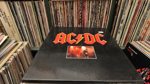 Vinylplatte von AC/DC auf einem Plattenstapel im Schallplattenladen