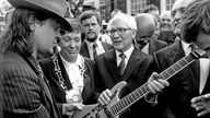 Udo Lindenberg überreicht dem ehemaligen SED-Generalsekretär Erich Honecker (M) bei dessen Besuch 1987 in Wuppertal eine - laut Lindenberg - "nicht ganz billige Gitarre" mit der Aufschrift "Gitarren statt Knarren"