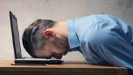 Ein Mann ist an seinem Laptop eingeschlafen (Symbolbild)