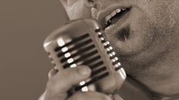 Mann singt in Mikrofon