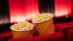 Popcorn steht zwischen den Sitzreihen in einem Kino im Cinestar Treptow.
