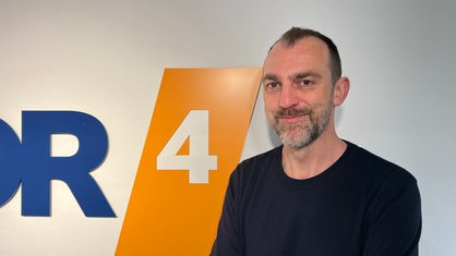 Michael Dietz vor dem WDR 4-Logo