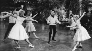 Filmszene aus "Holiday für dich und mich" (1962): Cliff Richard gemeinsam mit Tänzerinnen und Tänzern auf der Tanzfläche