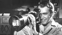  James Stewart mit einem Fotoapparat mit Teleobjektiv in der Hand