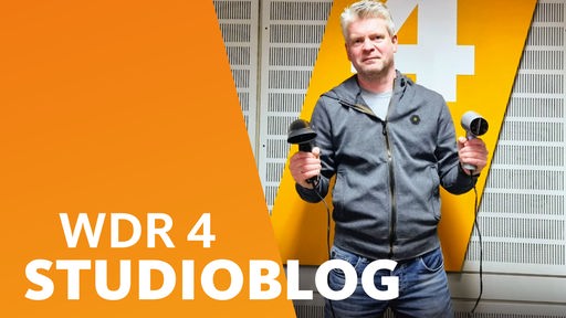 Ganz normale Sendungsvorbereitung bei WDR4? Stefan Vogt mit zwei Fönen in der Hand im WDR 4-Studio