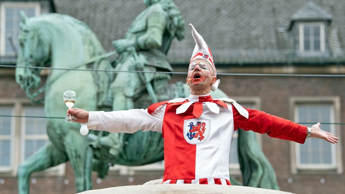 Die Düsseldorfer Karnevalsfigur Hoppeditz spricht am Rathaus vor dem Jan-Wellem-Reiterdenkmal
