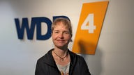 Claudia Heuermann vor dem WDR 4-Logo