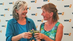 WDR 4-Moderatorin Heike Knispel und Kräuterexpertin Ursula Stratmann stoßen mit einem Kräuter-Smoothie an