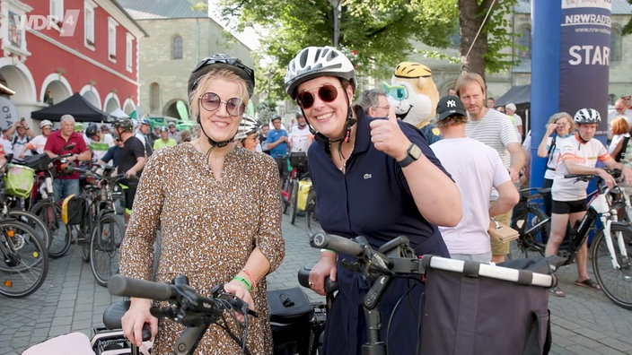 Zwei Radfahrerinnen bei der NRW Radtour winken in die Kamera