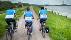 Probefahrt zur NRW Radtour 2023: Bastian Bender fährt gemeinsam mit zwei weiteren Radfahrern am Rhein entlang