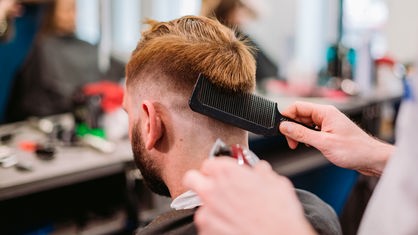 Ein Mann bekommt in einem Barber-Shop einen neuen Haarschnitt