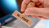 Ein Holzstempel mit dem Aufdruck "KI-FAKE"