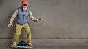 Modischer älterer Herr auf einem "One-wheeled electric skateboard"