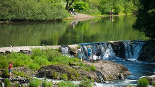 Menschen baden an dem Wasserfall bei Windeck