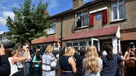 Eine Menschenmenge wartet vor dem ehemaligen Wohnhaus Freddie Mercurys in Feltham bei der Enthüllung der Blauen Plakette