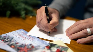 Ein Mann schreibt Weihnachtskarten
