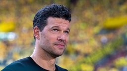 TV-Experte Michael Ballack steht vor der gelben Tribüne