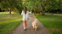 Eine Frau geht mit ihrem Hund im Park