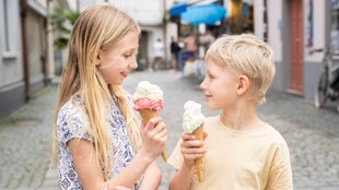 Lächelnde Geschwister mit Eis in der Hand