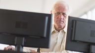 Senior professional working on computer, älterer Mann im Büro