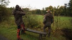 Ranger Torben Adler und Ralf Schmidt vom Landesbetrieb Wald und Holz NRW am Zaun des Geheges auf Hohenroth