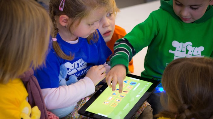 Kinder spielen an einem Tablet-PC