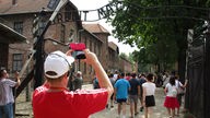 Touristen in Auschwitz machen Fotos