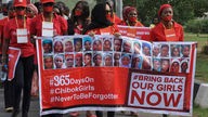 "Bring Back Our Girls"-Protest in Nigeria: Frauen und Männer tragen ein großes Transparent mit Fotos von entführten Mädchen und der Aufschrift: "Bring back our girls"