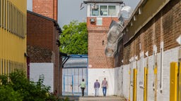 Das Beitragsbild des Dok5 "Ersatzfreiheitsstrafe - Streit um den Schuldturm für Arme" zeigt zwei Gefängnisinsassen auf dem Anstaltsgelände der Justizvollzugsanstalt Werl.