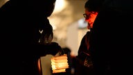 Eine entzündete Laterne in dunkler Umgebung auf einer Friedenskundgebung verschiedener Religiöser Gruppen