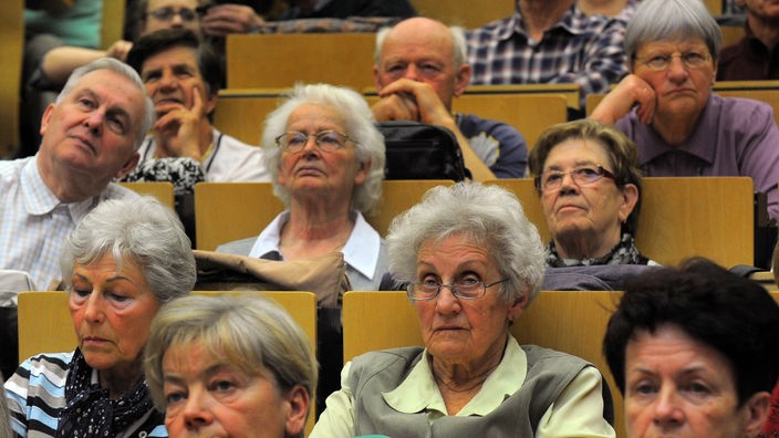 Lebenslanges Lernen, ältere Menschen über 60 Jahre sitzen in einem Hörsaal der Universität