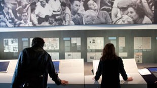 Menschen sehen sich in einer Ausstellung Bilder über Adolf Eichmann 